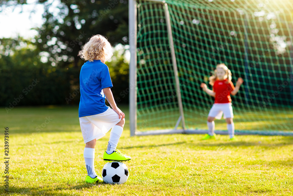 Obraz premium Kids play football. Child at soccer field.