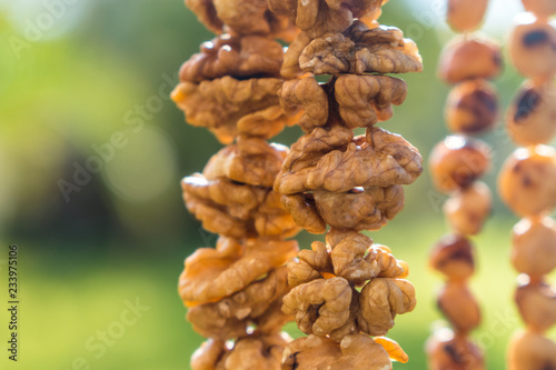 Walnuts halves on long thread - preparation blank for making churchkhela sweet dessert homemade candy photo