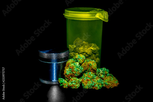 Obraz na płótnie A bright green RX bottle with marijuana inside it, a pile of marijuana buds infront & a bud grinder to the left. w salonie