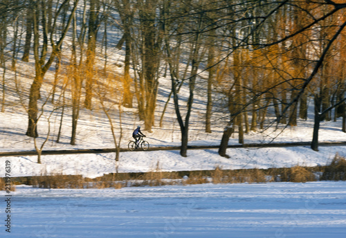A cyclist on a walk in winter Park. Winter landscape.