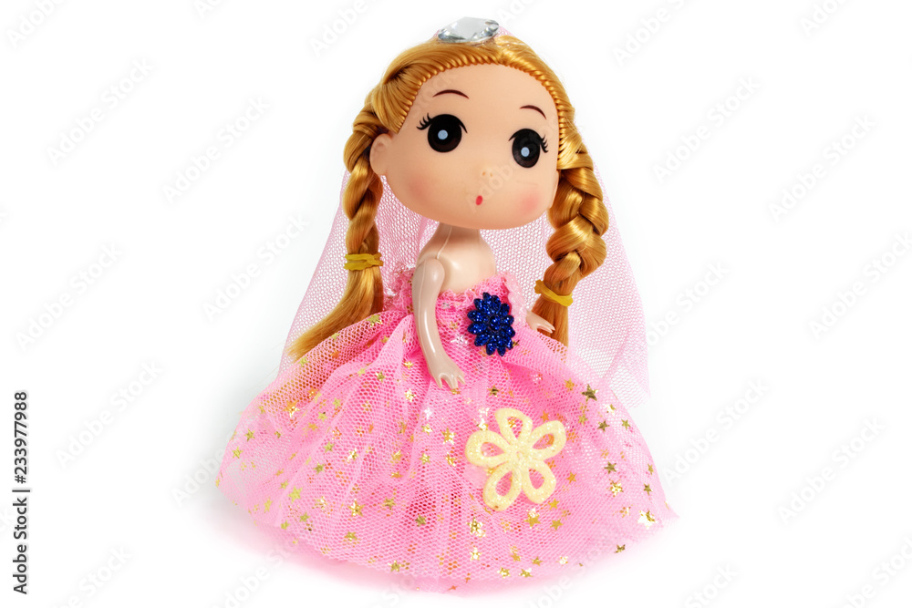 Cute doll is standing in a pink dress, as princess with flowers on white background