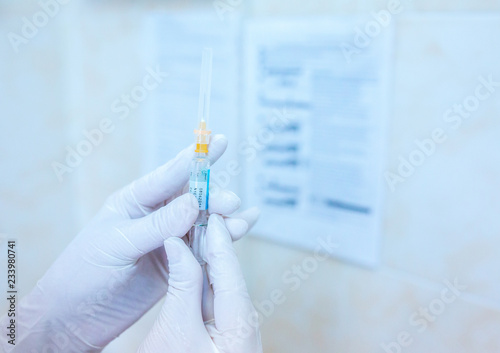 Nurse hand holding a syringe dose with vaccine or drugs, prepares for an injection. Medical concept: vaccination, injection, treatment disease, hospital, immunization, illness, disease.