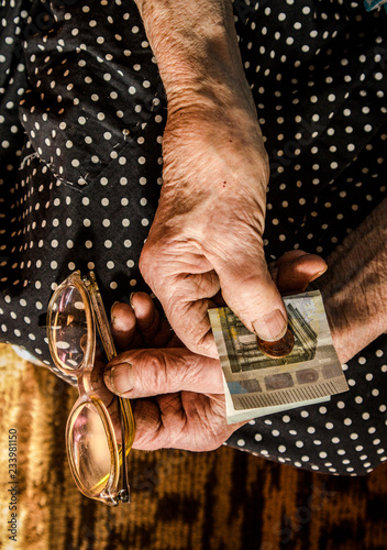 Obraz na plátne Hard working retired old woman holding money euros in her wrinkled hands