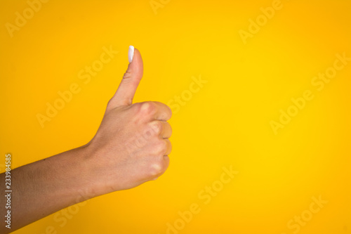 Woman hands over yellow background with copyspace