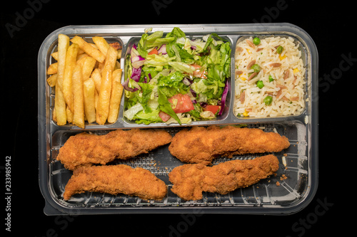 Chicken Goujons served with rice, salad and french friends on delivery box © Alp Galip