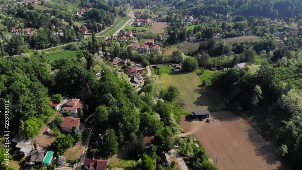 Aerial drone shot over the east european mountain village surrounded with forest. Lush green trees during Summer. Shot in 4K (UHD). Aerial drone shot over the east european mountain village surrounded with forest. Lush green trees during Summer. Shot in 4K (UHD).