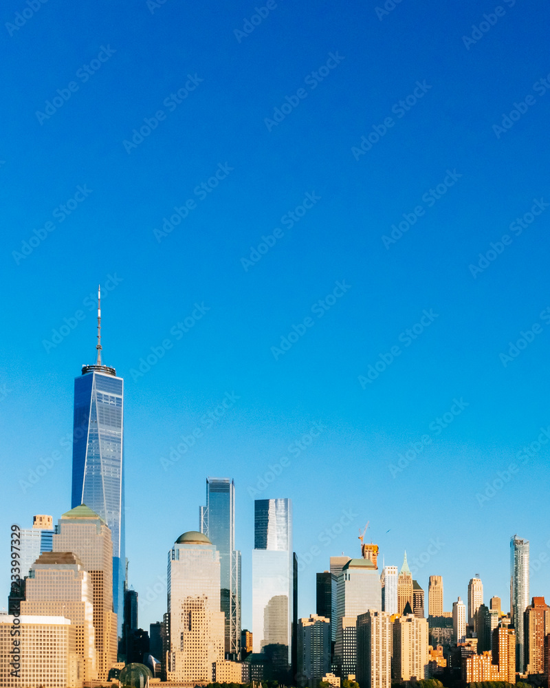 Skyline of downtown Manhattan under blue sky, at sunset, in New York City, USA