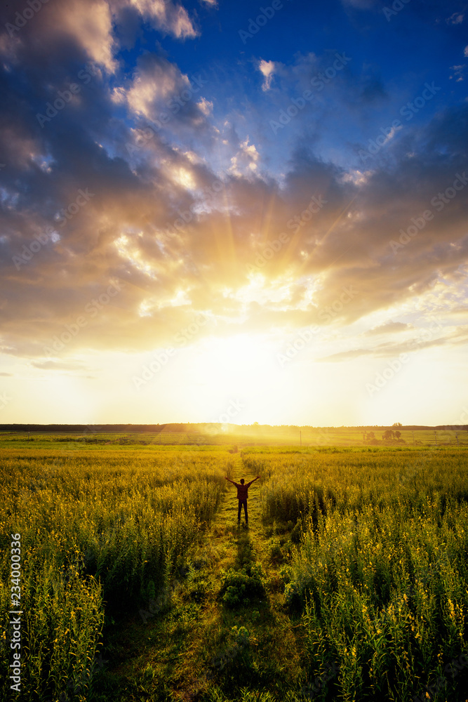 Feel good freedom concept. Happy young asian man enjoying freedom with open hands in farm and sunset sky background. - obrazy, fototapety, plakaty 