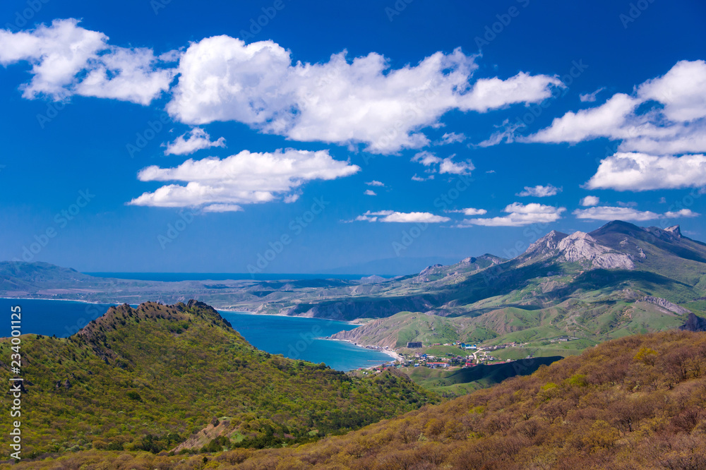 view from the mountains to the seashore with clouds in the blue sky view from the mountains to the seashore with clouds in the blue sky