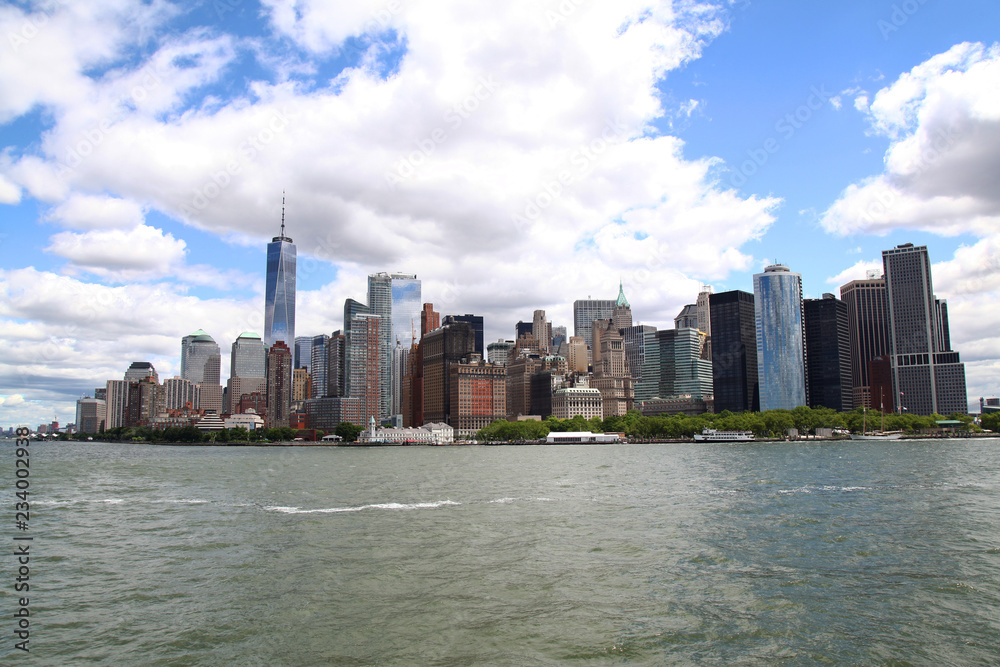 Fototapeta premium Nowy Jork, Usa-15 czerwca 2018 r .: Spójrz na żaglówkę pływa po budynkach portu w Nowym Jorku na wyspie Manhattan w tle
