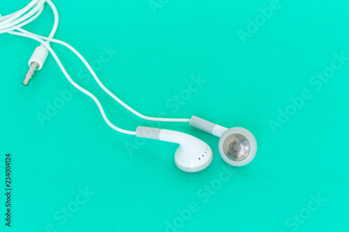 earbuds or earphones on green background