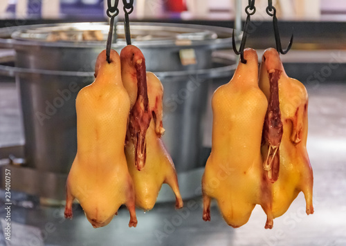 Traditional Chinese whole roast duck or da dong kaoya hanging on hooks or roasing in a Chinese Restaurant photo