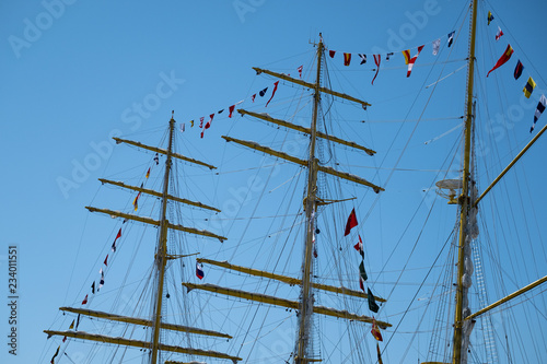 Masts of sailing ships against the blue sky.