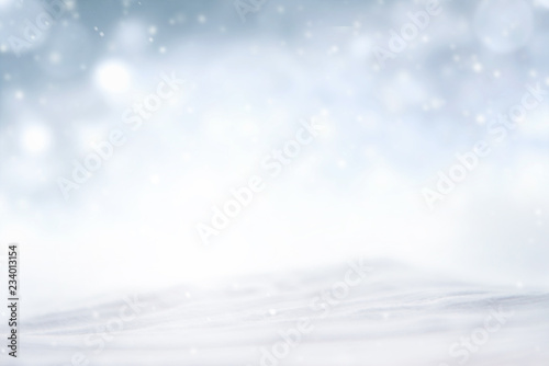 Snowflakes and snowfall on a cold blue winter background © oatawa