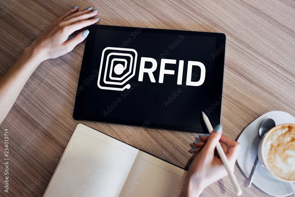 RFID Radio frequency identification technology concept on device screen. Security and automation. RFID Radio frequency identification technology concept on device screen. Security and automation.