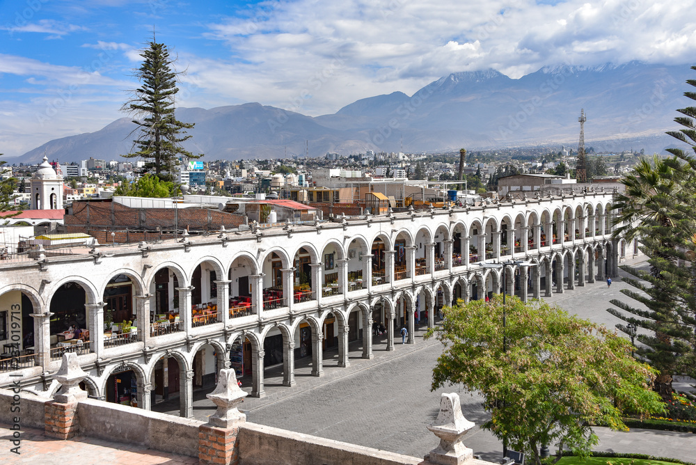 Arequipa, Peru - October 7, 2018: Colonial buildings and archways made of white Sillar stone in the Plaza de Armas, Arequipa