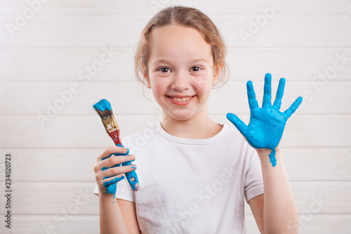 beautiful little girl with hands in the blue paint