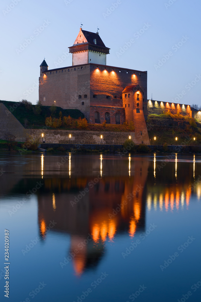 The medieval castle of Herman over the Narva river in the October twilight. Estonia