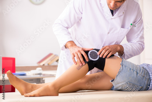 Male doctor checking joint flexibility with goniometer  