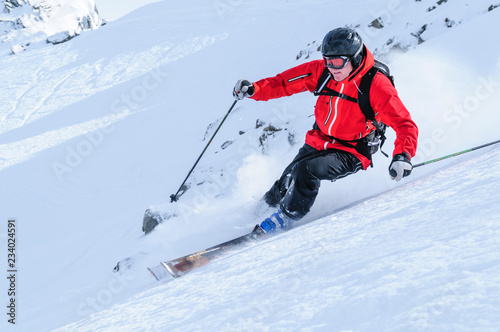 Skifahrer mit Schräglage im Gelände unterwegs