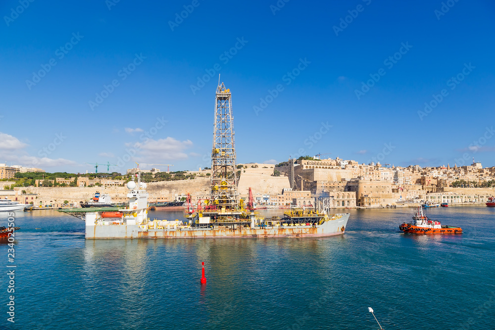 Valletta, Malta. Tugboats move a drilling ship in the Great Bay