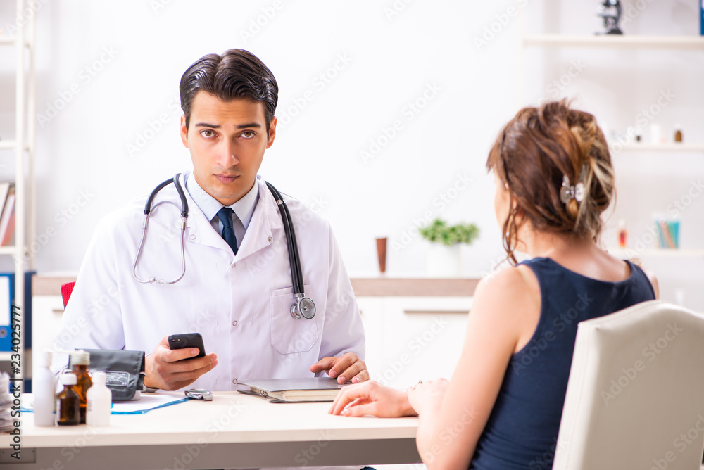 Young doctor checking woman's blood pressure Young doctor checking woman's blood pressure