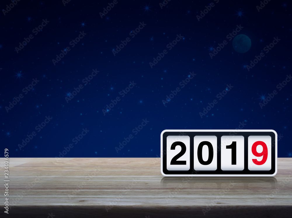 Retro flip clock with 2019 text on wooden table over fantasy night sky and moon, Happy new year 2019 cover concept