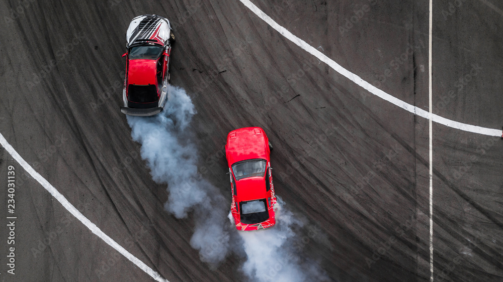 Aerial view two cars drift battle view from above, Activity two cars drift action battle on asphalt race track with abstract smoke.
