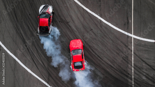 Aerial view two cars drift battle view from above, Activity two cars drift action battle on asphalt race track with abstract smoke. photo