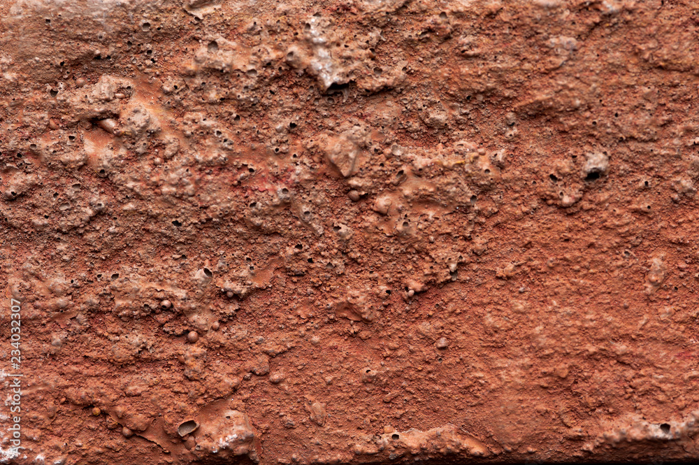 Macro shooting texture of red clay wall. Red clay earth for background usage. Texture of the old tough cragged wall of red color