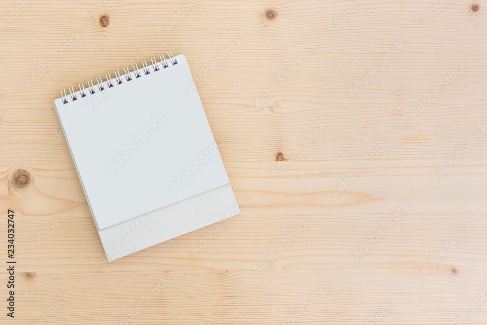 White blank paper desk spiral calendar on wood background.. White blank paper desk spiral calendar on wood background..