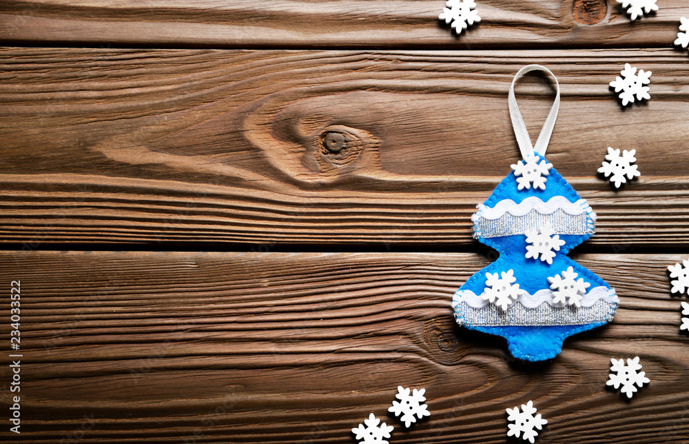 Handmade rustic felt Christmas tree decorations on wooden table Handmade rustic felt Christmas tree decorations on wooden table