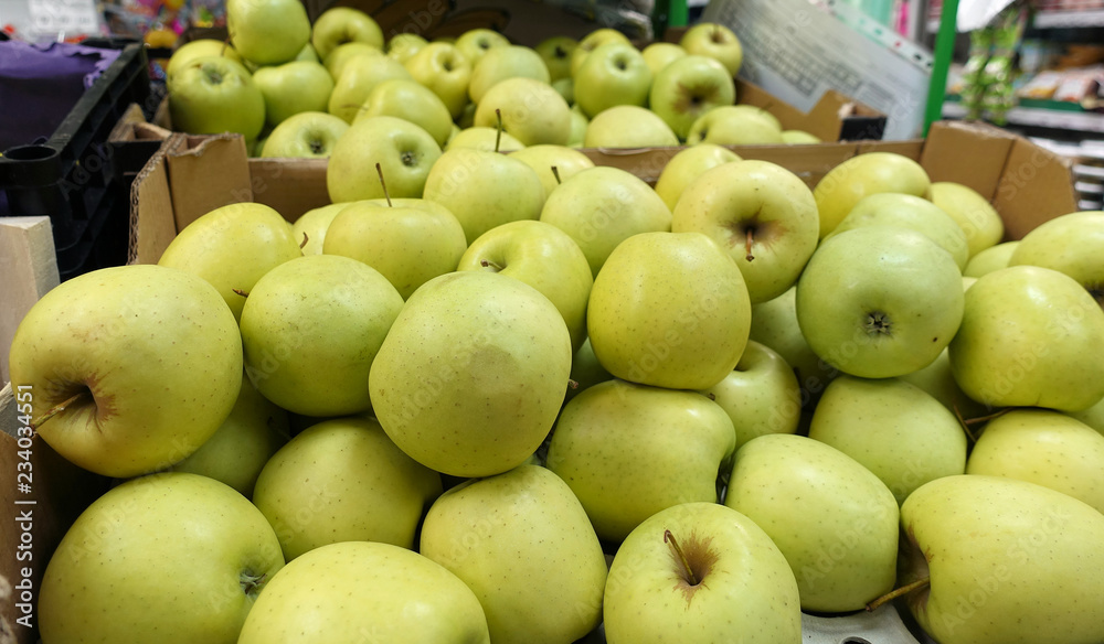 Fresh Golden Delicious juicy whole apples for sale in a store in boxes. Fresh Golden Delicious juicy whole apples for sale in a store in boxes.
