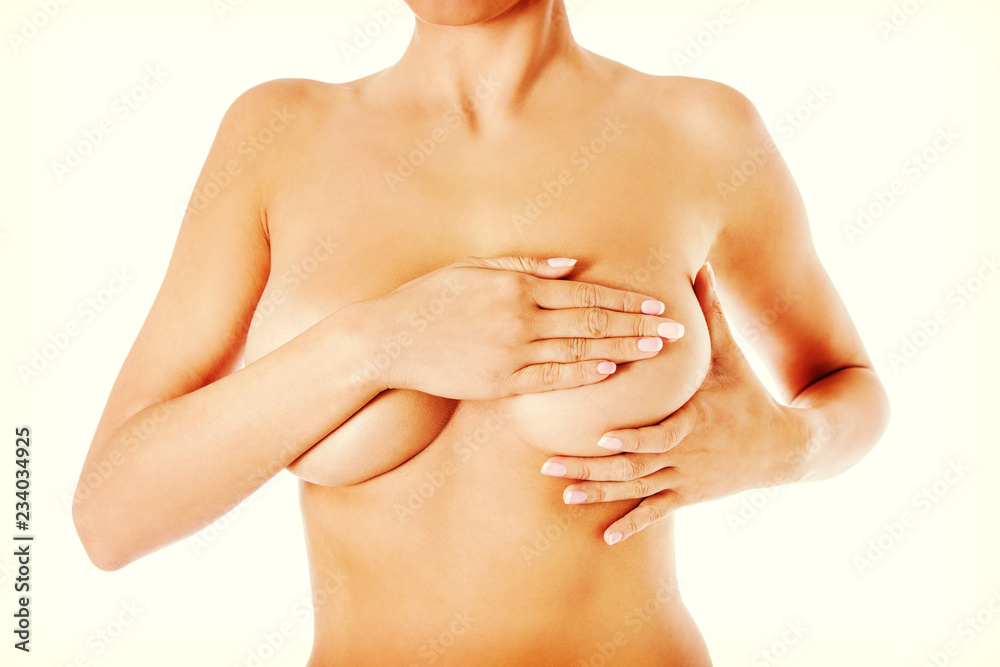 Fototapeta premium Young woman examining her breast for lumps or signs of breast cancer.
