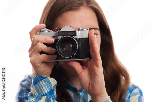 Young charming positive woman photographer with vintage camera in casual clothes on white background