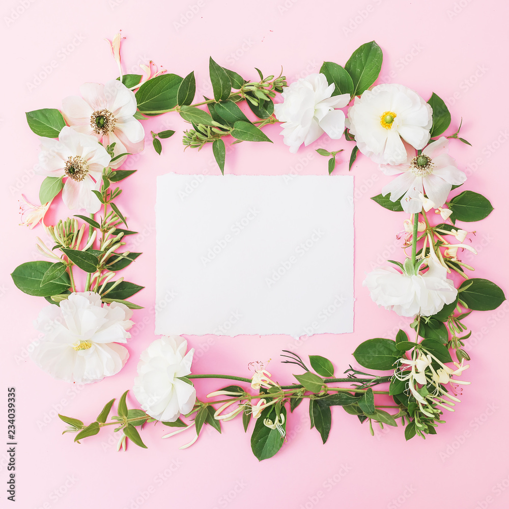 Floral frame of white flowers, buds with card on pink background. Flat lay, top view. Pastel background. Floral frame of white flowers, buds with card on pink background. Flat lay, top view. Pastel background.