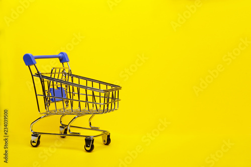 Shopping cart on yellow background