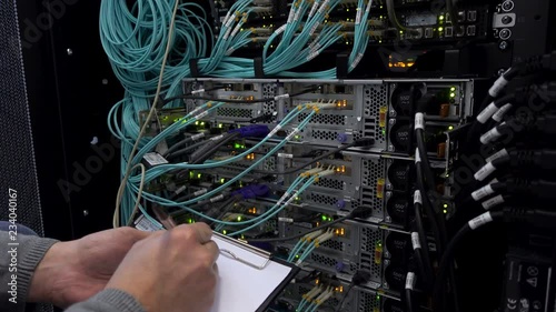 The engineer with the tablet in the server room. Check of the server hardware.