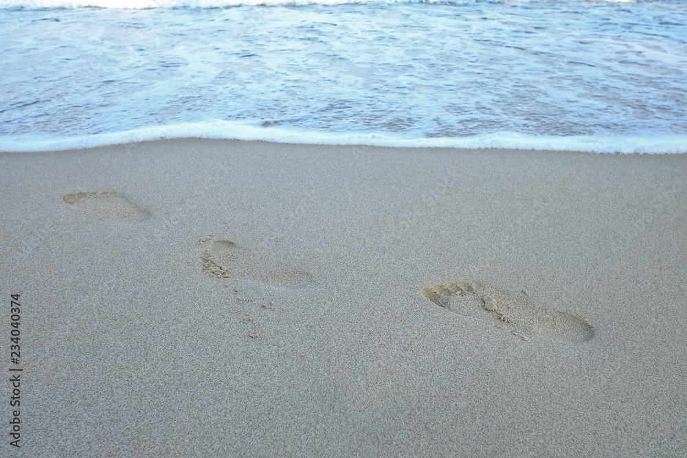 Footprint on sand beach with water waves background Footprint on sand beach with water waves background