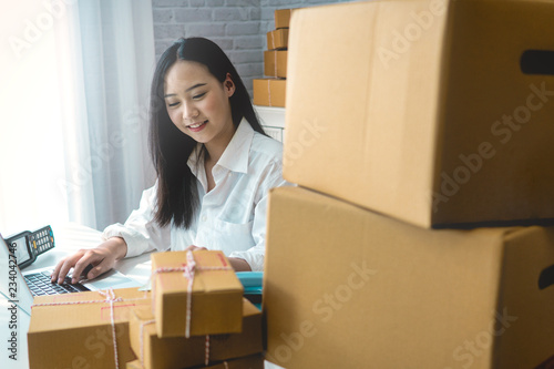 Business woman start up small business entrepreneur SME success .freelance woman working at home with Online Parcel delivery. SME and packaging  deliveryconcept