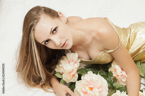 Young woman in golden dress with flowers.