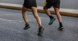 Marathon running race, two runners on city roads, detail on legs