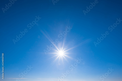 sparkle sun on the blue cloudy sky, nature background © Yuriy Kulik