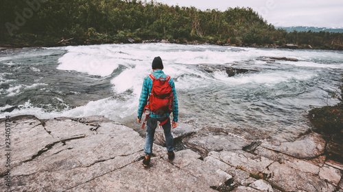 Man solo traveling hiking with backpack active adventure lifestyle journey vacations outdoor river in Sweden