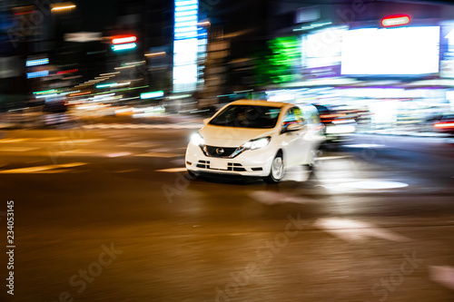 Car fast speed drive on asphalt road at night (Ueno area, Tokyo, Japan)