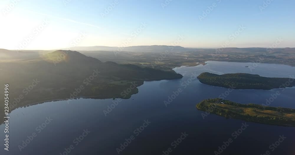 Inspiring and mystic aerial view from a drone of Loch Lomond in Scotland - Summer time with blue sky Inspiring and mystic aerial view from a drone of Loch Lomond in Scotland - Summer time with blue sky