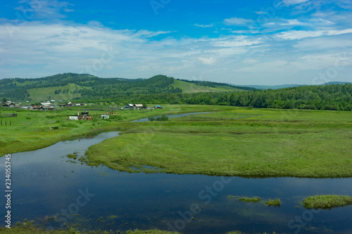 Rural landscape with houses, fields and mountains