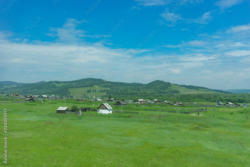 Rural landscape with houses, fields and mountains