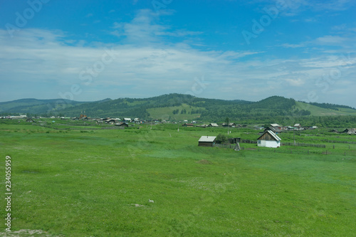 Rural landscape with houses, fields and mountains