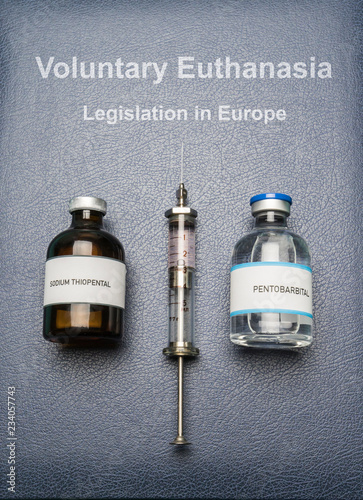 Book of voluntary euthanasia and legislation in Europe, vials of sodium thiopental anesthesia and pentobarbital, concept on euthanasia, composition digital imaginary photo